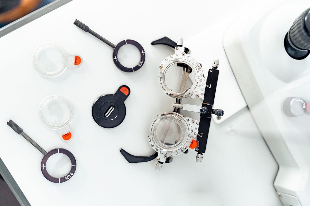 A trial frame and trial lenses laid out on a white surface